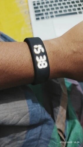 Black digital wristband on a person's wrist with a blurred background